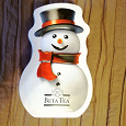 Отдается в дар Шкатулка -металлическая коробочка от чая в форме снеговика.