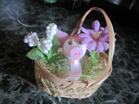 Отдается в дар Симпатичный забавный сувенир. Маленькая плетеная корзинка с поросенком среди цветов.